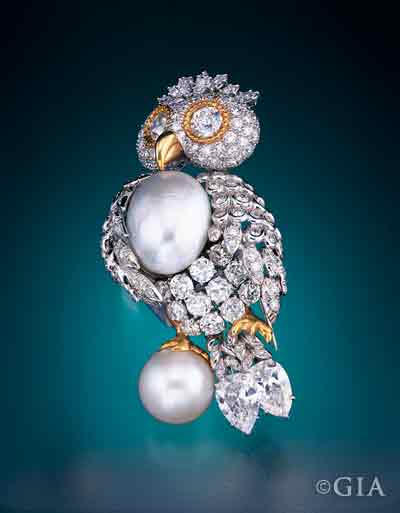 This platinum and yellow gold owl brooch has a pavé diamond head and body with large pearl accents for its chest and perch. Note the intricate pavé work and the attention to detail.