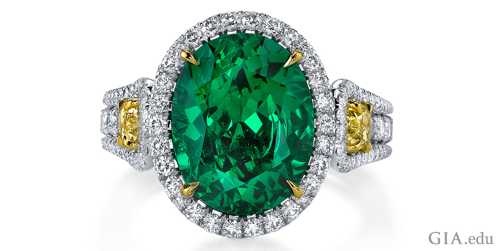 A 5.55 ct oval tsavorite garnet ring, with two fancy yellow diamonds weighing a total of 0.71 ct, and 136 round diamonds weighing 1.02 ct total weight, set in platinum.